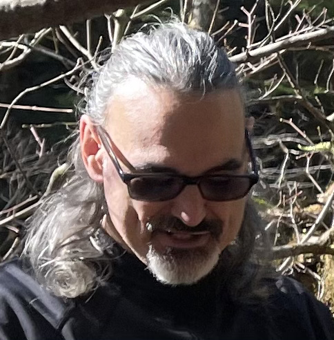 Al Gonzalez outdoors, sunglasses and gray hair, smiling